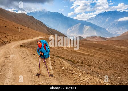 Trekking dans l'Himalaya. Jeune femme sur une route de montagne poussiéreuse à Lower Mustang, au Népal Banque D'Images