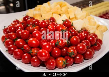 Beaucoup de tomates cerises et trancher l'ananas dans un grand bol. Banque D'Images
