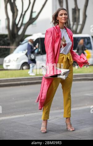 19 février 2020: 19 février 2020: Le mannequin porte un pantalon jaune et un pardessus rose pendant le défilé de mode Armani à la semaine de la mode pour femmes Banque D'Images