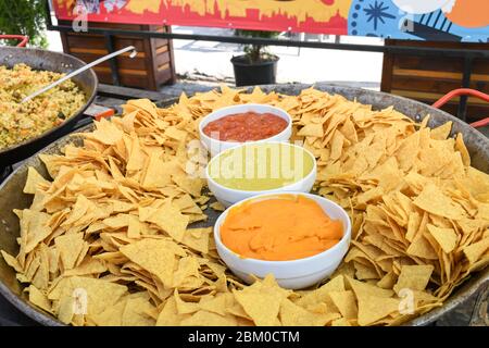 Une très grande assiette ou un bol de nachos servi avec trois types de sauce : guacamole, sauce Chili et fromage.tortilla Nacho avec sauce crème servie à la nourriture f Banque D'Images
