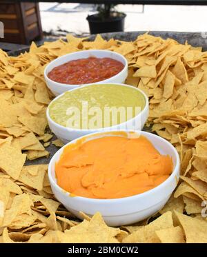 Une très grande assiette ou un bol de nachos servi avec trois types de sauce : guacamole, sauce Chili et fromage.tortilla Nacho avec sauce crème servie à la nourriture f Banque D'Images