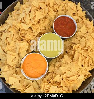 Une très grande assiette ou un bol de nachos servi avec trois types de sauce : guacamole, sauce Chili et fromage.tortilla Nacho avec sauce crème servie à la nourriture f Banque D'Images