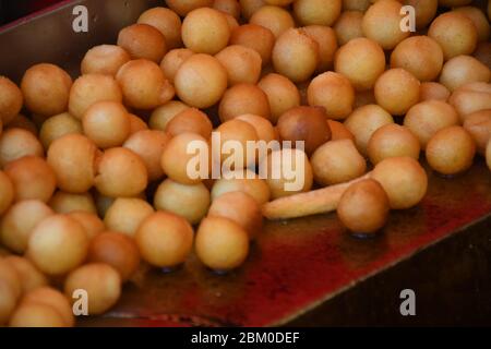 Beaucoup de petits beignets ronds frits, simples, sans sirop ni sauce. Grand bol de beignets isolés, prêts à être servis pendant le festival de la nourriture ou c Banque D'Images