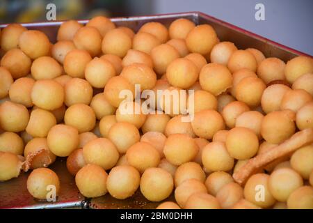 Beaucoup de petits beignets ronds frits, simples, sans sirop ni sauce. Grand bol de beignets isolés, prêts à être servis pendant le festival de la nourriture ou c Banque D'Images