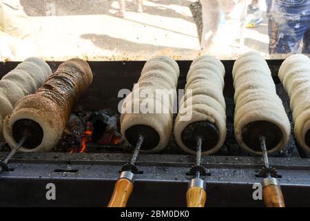 Kurtos kalacs ou des gâteaux de cheminée, la préparation de la cuisine sur le charbon de bois, la rue de cuisine traditionnelle hongroise, pendant le festival de la nourriture. Kurtos Kalacs traditiona Banque D'Images