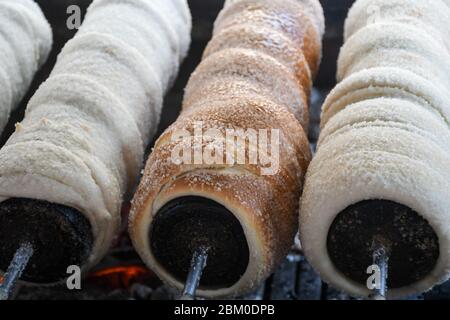 Kurtos kalacs ou des gâteaux de cheminée, la préparation de la cuisine sur le charbon de bois, la rue de cuisine traditionnelle hongroise, pendant le festival de la nourriture. Kurtos Kalacs traditiona Banque D'Images