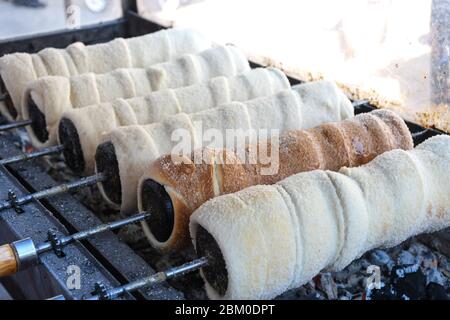 Kurtos kalacs ou des gâteaux de cheminée, la préparation de la cuisine sur le charbon de bois, la rue de cuisine traditionnelle hongroise, pendant le festival de la nourriture. Kurtos Kalacs traditiona Banque D'Images