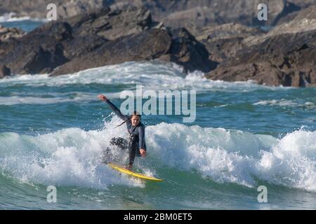 Une femelle à surfer une vague de Fistral Newquay en Cornouailles. Banque D'Images