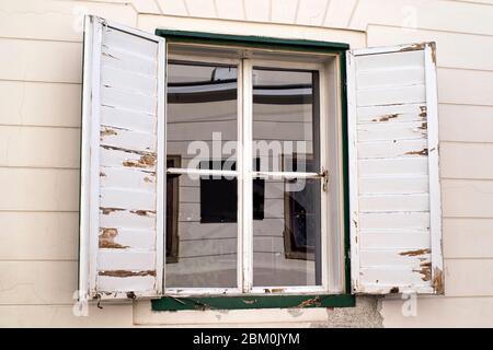 Rangée de volets anciens de fenêtre aux couleurs blanches.fenêtre avec volets anciens en bois blanc.ancienne fenêtre avec volets en bois blanc dans une ancienne maison en bois de W Banque D'Images