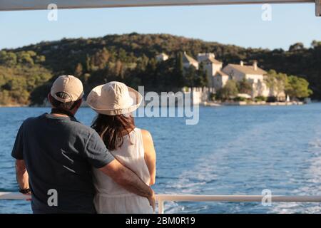 Un couple en cuddled sur un bateau qui regarde dans le paysage de la mer Banque D'Images