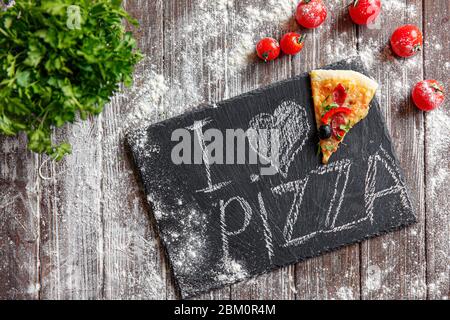 De dessus morceau de pizza sur un tableau avec j'aime pizza sur table en bois. J'adore le concept de pizza. Banque D'Images
