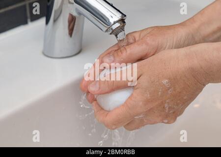 mains avec du savon sous le robinet d'eau Banque D'Images