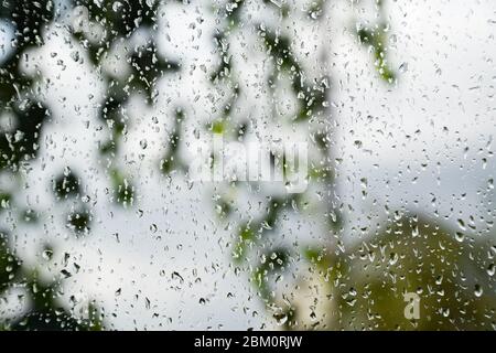 Gouttes de pluie sur le volet de la fenêtre. Arrière-plan flou à l'extérieur de la fenêtre sous la pluie. Banque D'Images