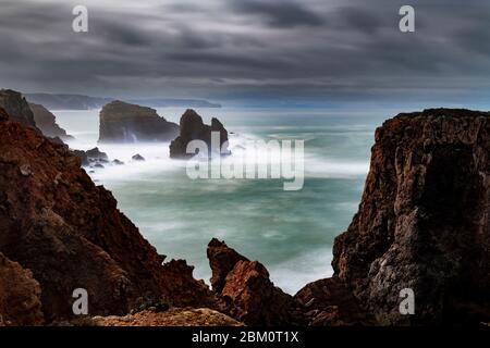 Vue panoramique sur la côte le long de Carrapateira avec les formations rocheuses et les vagues qui s'écrasant pendant une tempête, en Algarve, Portugal Banque D'Images