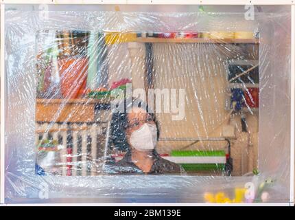 Dresde, Allemagne. 06e mai 2020. Une vendeuse de fleurs se trouve dans le hall du marché de Neustadt, dans son magasin, derrière un bouclier de sphite et porte un protège-bouche. Crédit : Robert Michael/dpa-Zentralbild/dpa/Alay Live News Banque D'Images