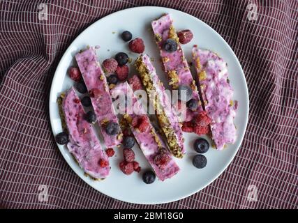 Barres de yaourt maison rose surgelées avec framboises et bleuets. En-cas pour les journées d'été Banque D'Images