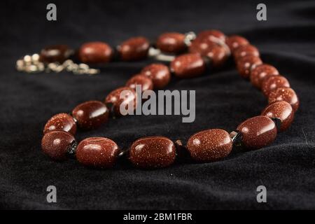 aventurine perles sable doré pierre semi-recieuse sur velor noir. gros plan Banque D'Images