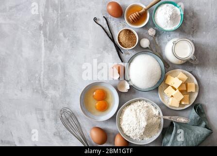 Ingrédients à cuire : farine, œufs, sucre, beurre, lait et épices sur fond de marbre gris. Vue de dessus. Espace pour le texte Banque D'Images