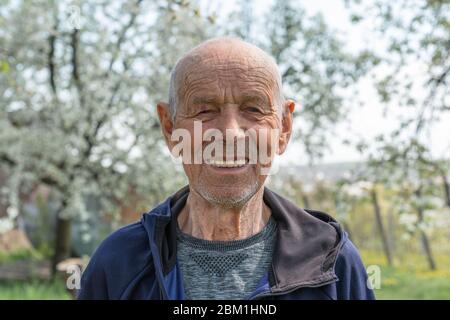 Gros plan portrait d'un vieil homme heureux retraité dans les vêtements de sport qui sourient et regardant l'appareil photo Banque D'Images