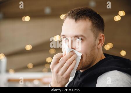 L'homme souffle sur le foulard et la toux, élimine le mucus. Concept grippe, froid en hiver. Banque D'Images