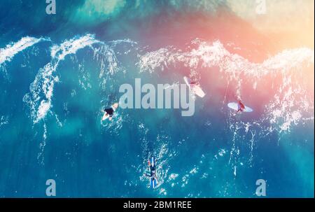 Le groupe de surfeurs novices apprend à s'embarquer sur la vague. Vue supérieure de l'antenne. Banque D'Images