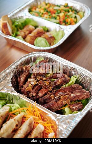 Plateau de feuilles avec délicieux repas de côtes de porc grillées au barbecue, sauce douce et salade fraîche Banque D'Images