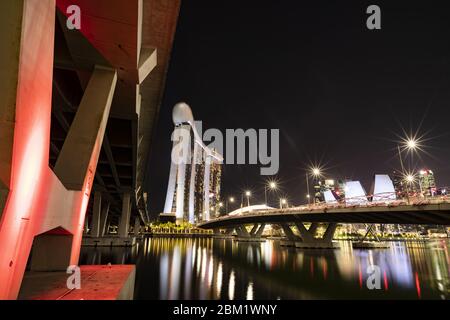 (Mise au point sélective) vue imprenable sur la ville illuminée de Singapour la nuit avec le pont Helix au premier plan. Banque D'Images