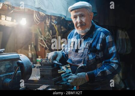 Mécanicien senior de turner masculin travaillant sur machine-outil pour métal Banque D'Images