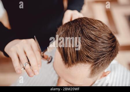 Gros plan maître Barber fait la coiffure et le coiffage avec sèche cheveux à Guy. Concept Barbershop Banque D'Images