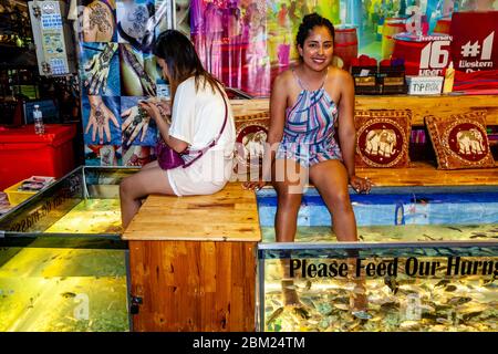 Un touriste souriant ayant UNE Pedicure de poisson, Pub Street, Siem Reap, Cambodge. Banque D'Images