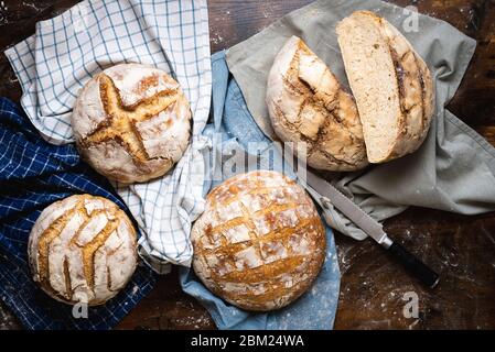 Pain maison avec levain et farine blanche. Vue ci-dessus avec plusieurs pains au levain sur les serviettes de cuisine. Banque D'Images