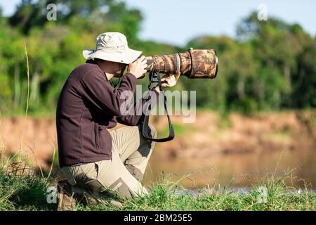 Photographe de la faune qui photographie dans la savane Banque D'Images