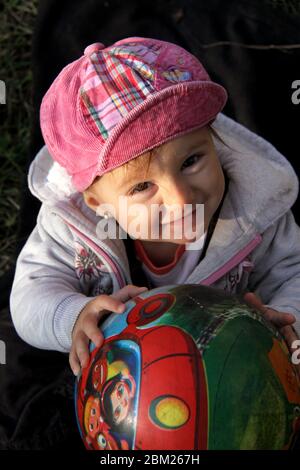 Bonne petite fille avec une balle dans la cour Banque D'Images