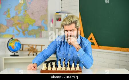 Figures sur le plateau d'échecs. Réfléchir à l'étape suivante. Faites votre propre pensée de manière indépendante. Leçon d'échecs. Concept de stratégie. Enseignant d'école. Jeu de société. Homme intelligent jouant aux échecs. Passe-temps intellectuel. Banque D'Images