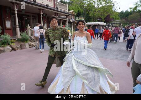 Les acteurs de Kiss la grenouille marchent en souriant comme Tiana et le prince Naveen à travers la rue du parc à thème à Disneyland. Paris France, 29. Mai 2019. Banque D'Images