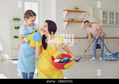 Une famille heureuse nettoie la chambre dans la maison. Mère père et petite fille enfant laver dans des gants tout en s'asseoir sur le sol souriant joyeux. Hygiène W Banque D'Images