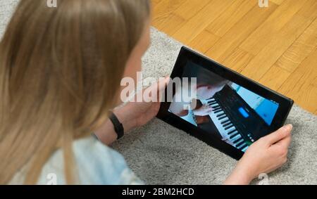 L'enseignant regarde comme fille joue le piano. Enseignement à domicile. Banque D'Images