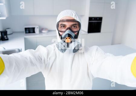 Gros plan photo de gars travailleur nettoyant blogger dans le travail de coverall travailleur faire selfie appel vidéo tenir caoutchouc jaune gants en latex dans la cuisine maison Banque D'Images