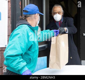 Newark, New Jersey, États-Unis. 6 mai 2020. Le révérend AL SHARPTON, président et fondateur du réseau action, remet un paquet de soins de nourriture et de masques à un résident de Newark dans le monde technologique du réseau action National. Crédit : Brian Branch Price/ZUMA Wire/Alay Live News Banque D'Images