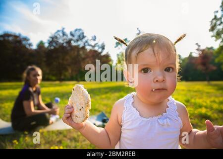 Une jeune mère avec son enfant fait du sport dans le parc. Petite fille ont du plaisir pendant que maman fait des exercices. Banque D'Images