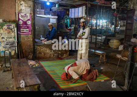 Les travailleurs d'un marché de gros sont vus à l'intérieur de la mosquée en priant pendant le mois Saint du Ramadan à Dhaka, au Bangladesh, le 06 mai 2020. Banque D'Images