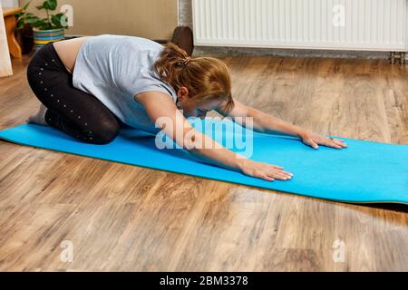 Belle femme d'âge moyen d'apparence européenne médite tout en pratiquant le yoga à la maison, lieu pour le texte. Banque D'Images