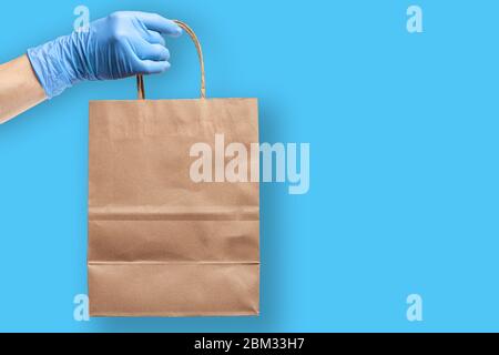 Gants de protection en caoutchouc pour tenir à la main, pour le sac à provisions en papier. Concept d'achat et de livraison d'épicerie pendant une pandémie de virus. Banque D'Images