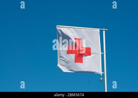 Le drapeau du mouvement international de la Croix-Rouge et du Croissant-Rouge contre un ciel bleu à Manno, en Suisse. La Croix-Rouge est une humanitaire internationale Banque D'Images