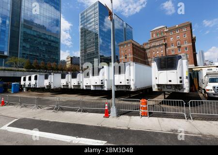 Camions frigorifiques temporaires garés derrière l'installation principale des examinateurs médicaux de New York pour les victimes de Covid-19 Banque D'Images