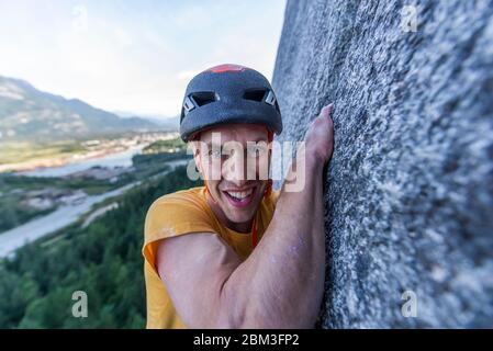 Homme luttant plomb grimpant dans la large montée sur le granite Squamish Banque D'Images