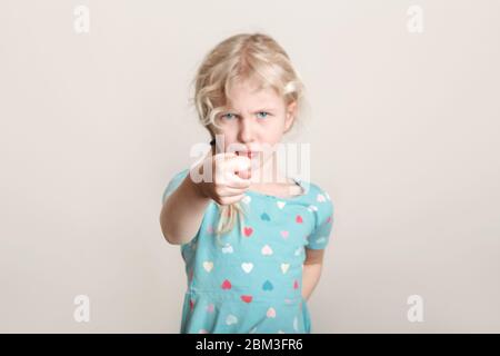 Enfant fille montrant le symbole figuier. Enfant exprimant une forte émotion négative. Adorable adorable jeune fille blanche d'âge préscolaire poser en studio Banque D'Images