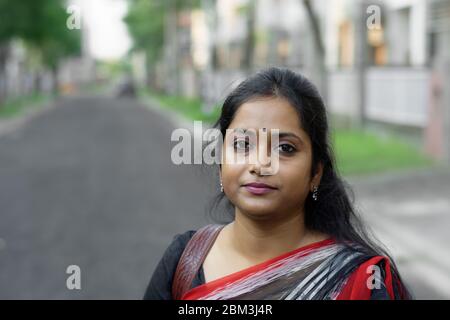 Portrait d'une femme brune indienne souriant dans la rue Banque D'Images