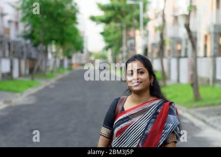 Portrait d'une femme brune indienne souriant dans la rue Banque D'Images