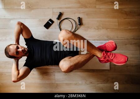 homme faisant le meilleur entraînement abs exercices. jeune gars abs s'entraîner à la maison. Banque D'Images